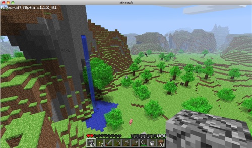 A lush new world in Minecraft. That grey pixelly bit at the front is a block of stone that I'm holding. But don't look at that - look at the incredible view and that awesome waterfall!