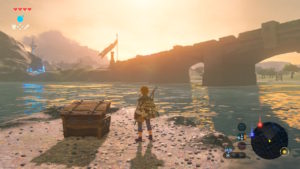 A screenshot of Breath of the Wild, with Link looking out over a sunrise above a bridge over a lake.